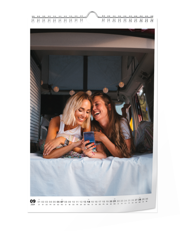 Fotokalender A4 Hoch Digitaldruck matt zeigt zwei Frauen, die gemeinsam lachend auf ein Handy schauen.