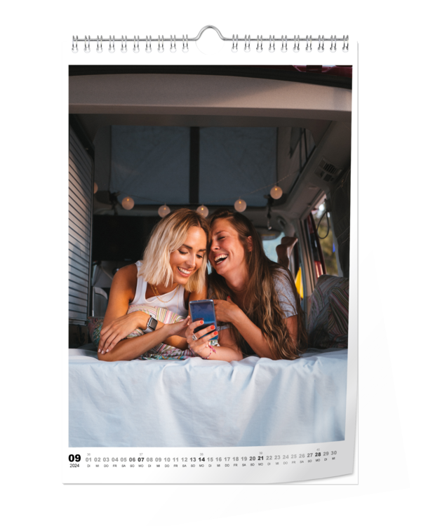 Fotokalender A4 Hoch Digitaldruck matt zeigt zwei Frauen, die gemeinsam lachend auf ein Handy schauen.